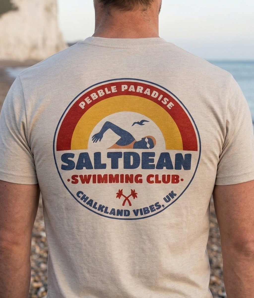 Man wearing a t-shirt with Saltdean Swimming Club logo on a beach