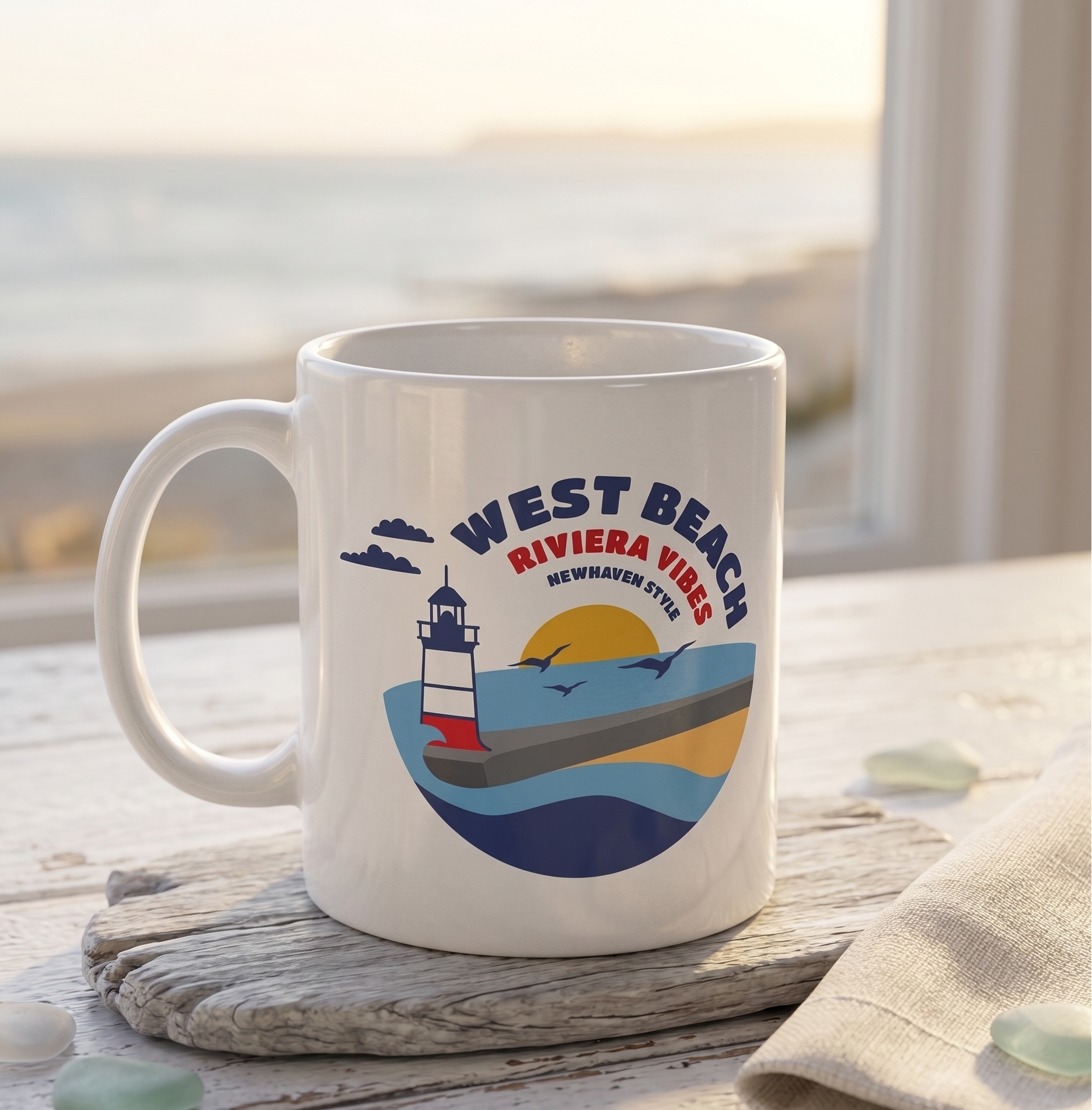 White mug with a lighthouse design and 'West Beach Riviera Vibes' text on a wooden surface.